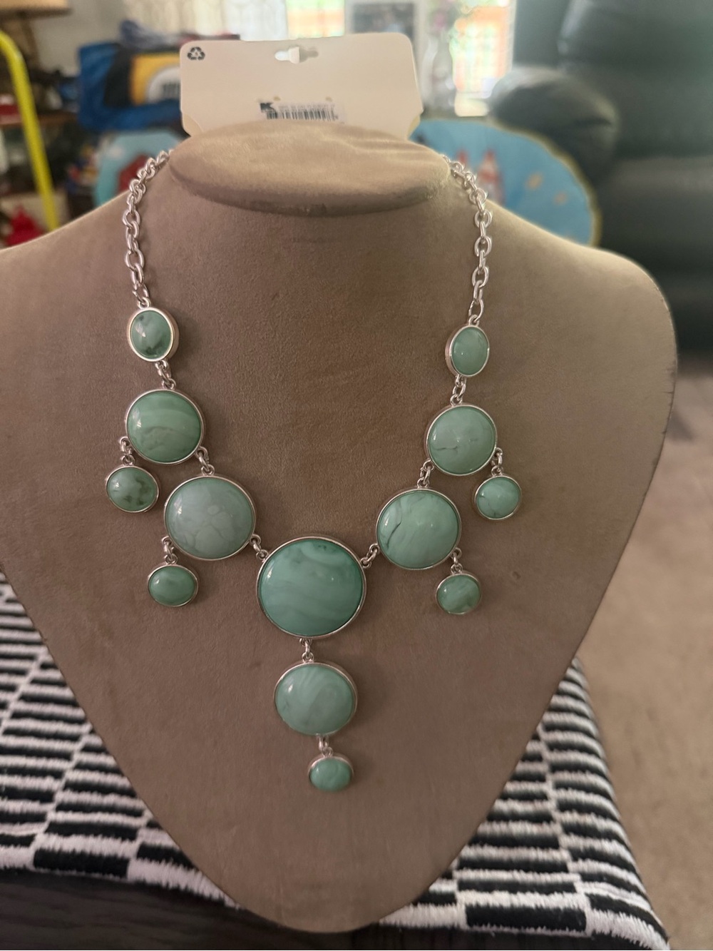 Silver-tone bib necklace features chunky, round green stones.